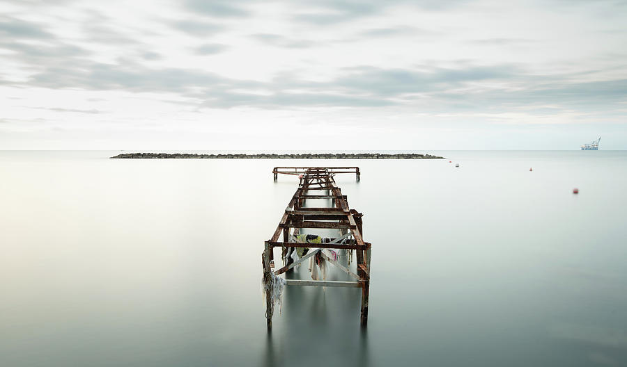 Seascape with old deserted industrial jetty at sunset. Photograph by Michalakis Ppalis