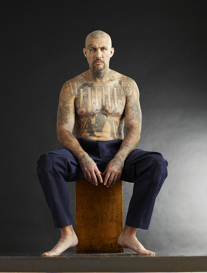 Seated tattooed man in studio. Photograph by Blake Little