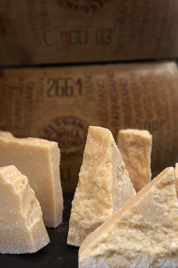 Sections of parmesan cheese on market stall, close-up Photograph by Michael Blann
