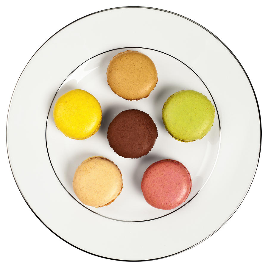 Selection of six macaroons on a white plate Photograph by Creative Crop