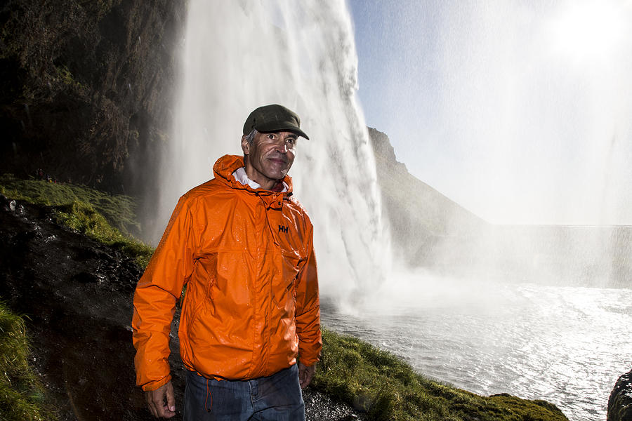 Seljalandsfoss and man walking Photograph by Stephanie Hager - HagerPhoto