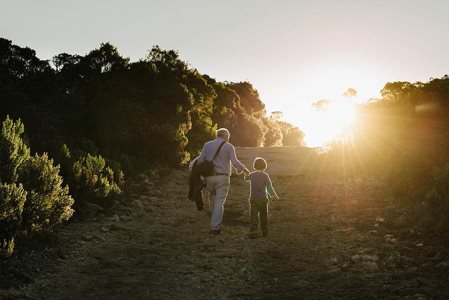 Senior adult and little boy walking on the road of Itatiaia National Park, Brazil Photograph by Igor Alecsander