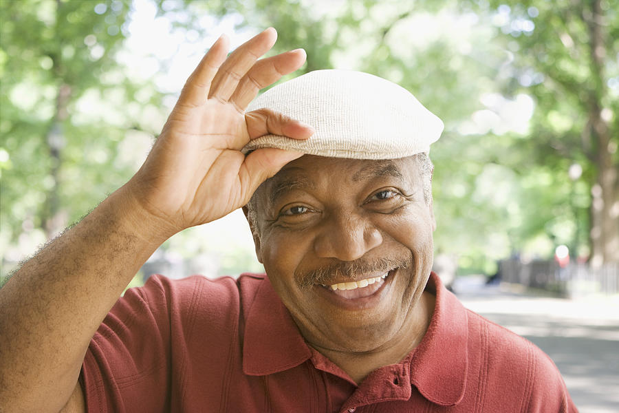 Senior African man tipping hat Photograph by Jose Luis Pelaez Inc