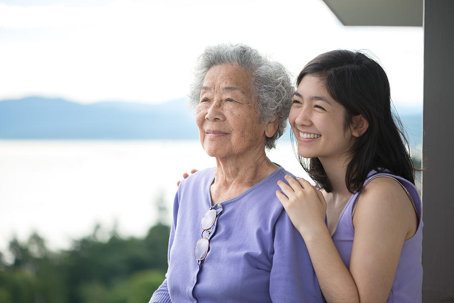 Senior Asian Woman and Granddaughter Enjoying View from Balcony Photograph by PamelaJoeMcFarlane