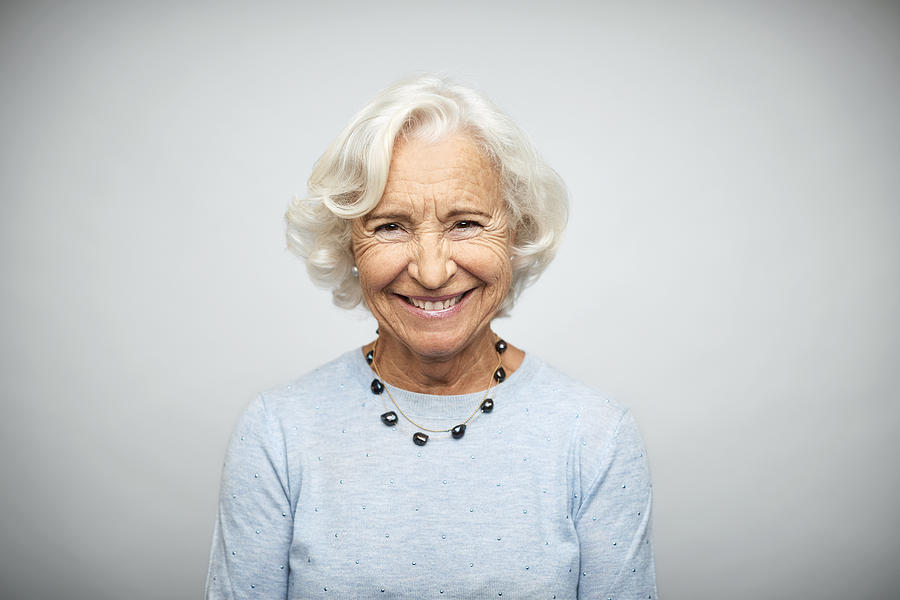 Senior businesswoman smiling on white background Photograph by Morsa Images