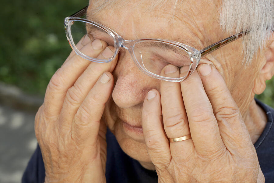 Senior caucasian woman rubbing her eyes under eyeglasses Photograph by Triocean
