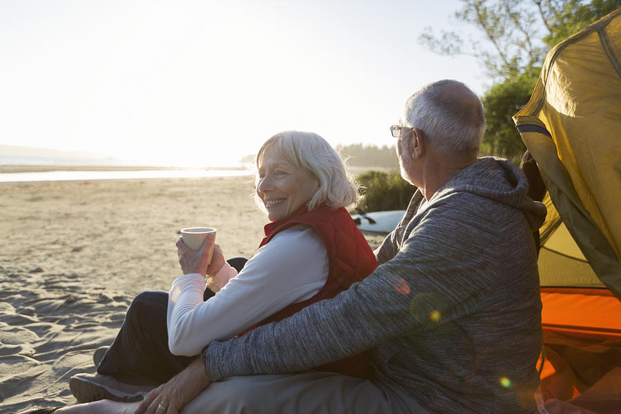 Senior couple camping on beach looking at ocean view Photograph by Compassionate Eye Foundation/Steven Errico