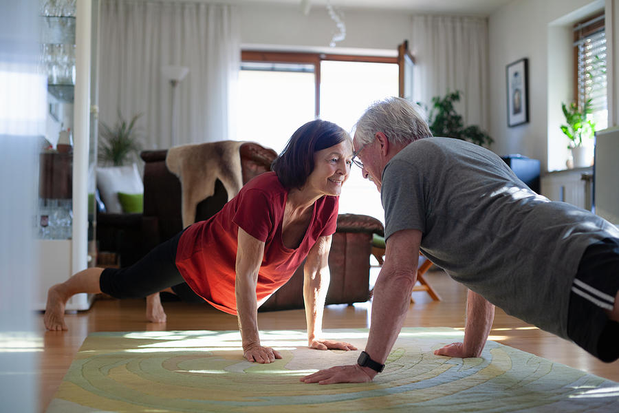 Senior couple exercising at home Photograph by Kathrin Ziegler