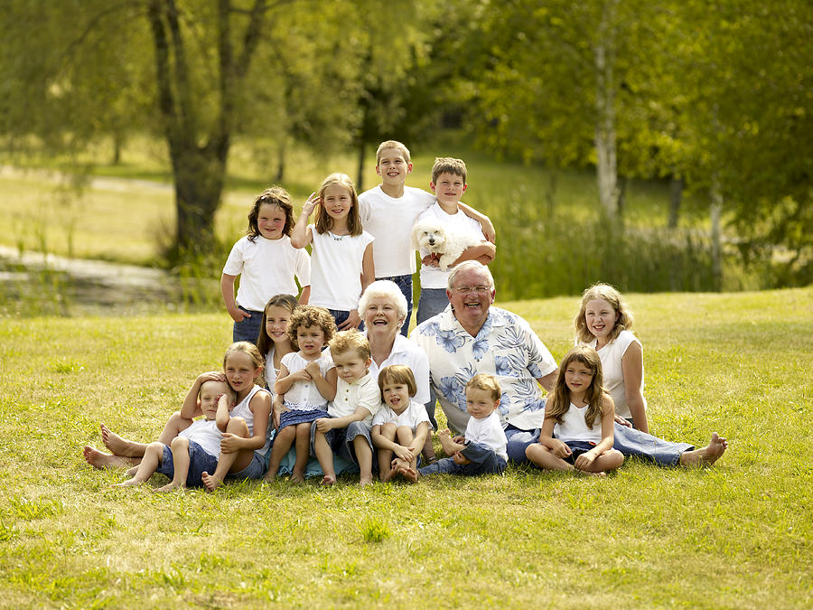 Senior couple with children outdoors, smiling, portrait Photograph by Lwa