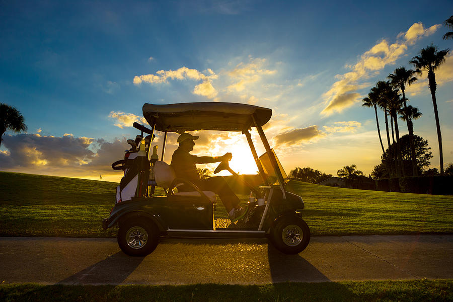 Senior golfer driving golf cart Photograph by Nycshooter