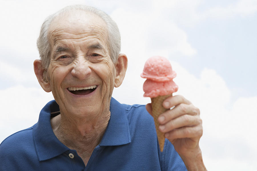 Senior Hispanic man holding ice cream cone Photograph by Jose Luis Pelaez Inc