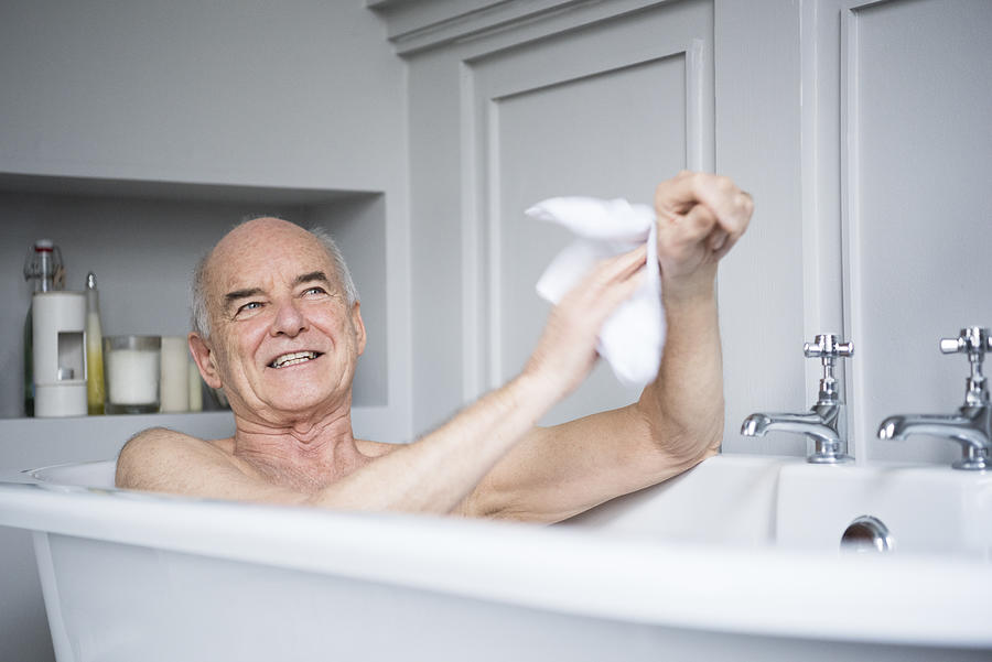 Senior man in bath washing himself smiling Photograph by JohnnyGreig