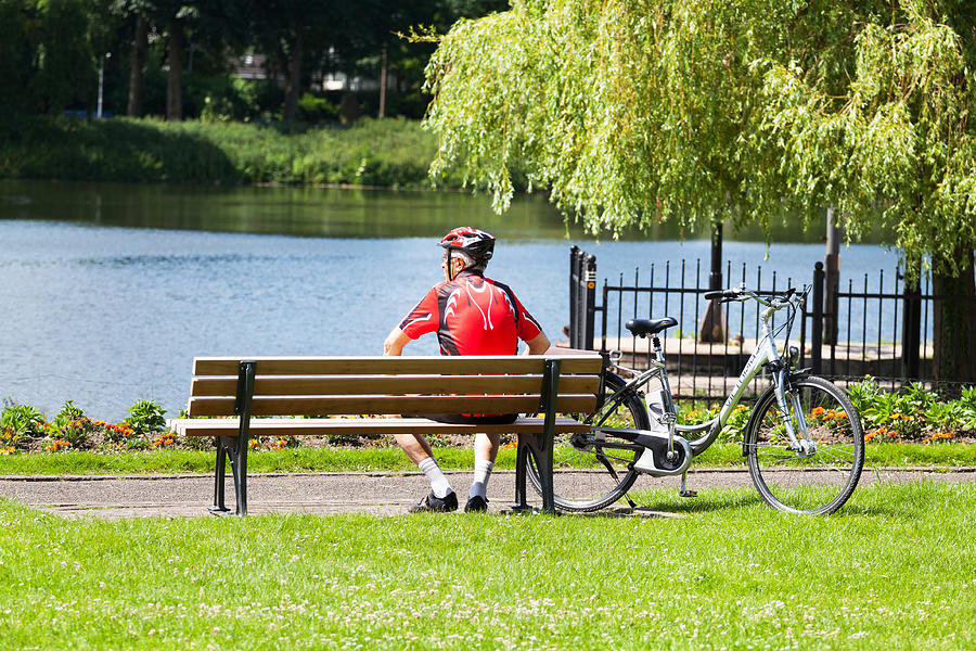 Senior man in sports dress relaxing on bench at Ruhr Photograph by Justhavealook