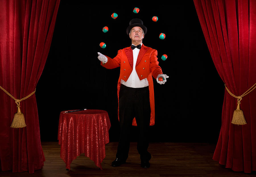 Senior man juggling balls on stage Photograph by Tim Platt