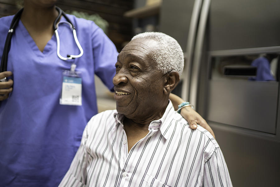 Senior man sitting, nurse behind him Photograph by FG Trade