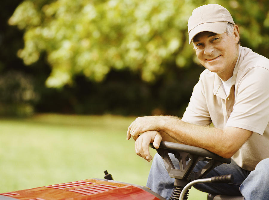 Senior Man Sitting on a Motorised Lawn Mower Photograph by Flying Colours Ltd