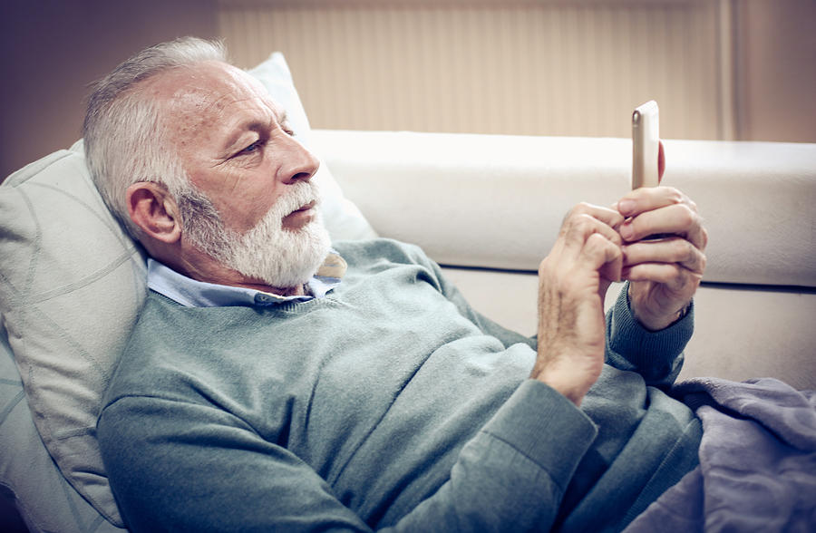 Senior man using smart phone. Photograph by Mladen Zivkovic