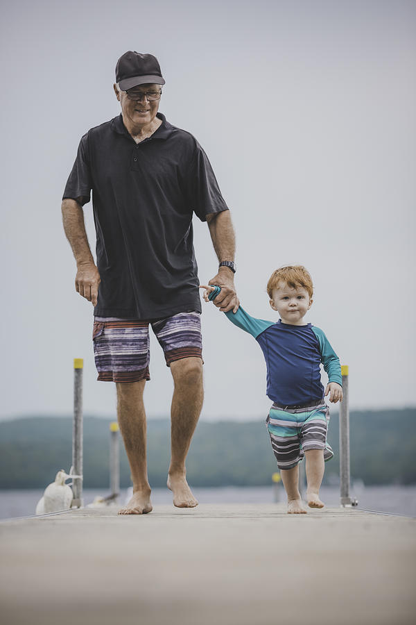 Senior Man with little boy at the lake, summer day Photograph by Onfokus