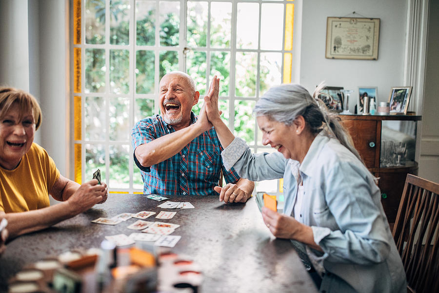 Senior people playing cards in nursing home Photograph by South_agency
