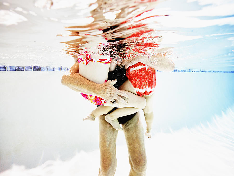 Senior woman holding granddaughters in pool Photograph by Thomas Barwick Senior woman holding granddaughters in pool Photograph by Thomas Barwick