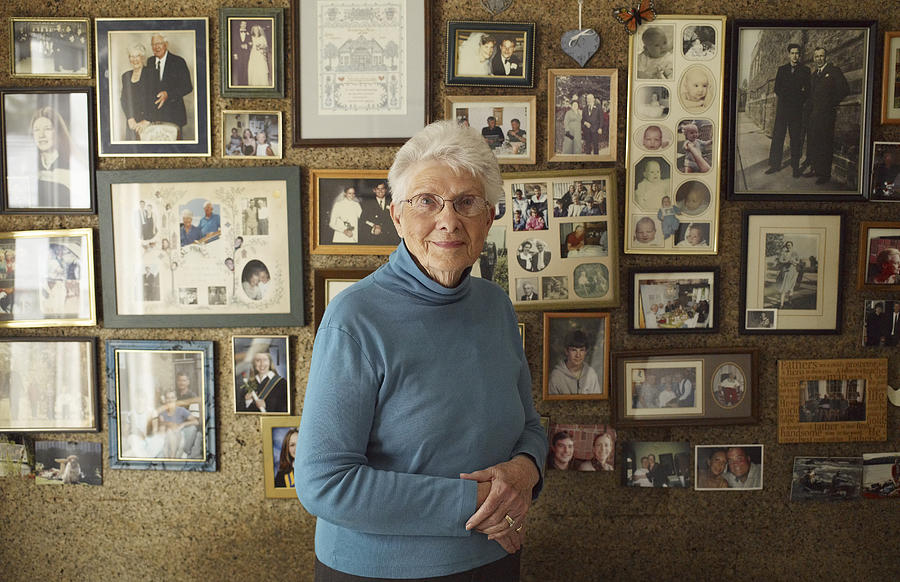 Senior Woman in Front of Family Photos Photograph by Lwa