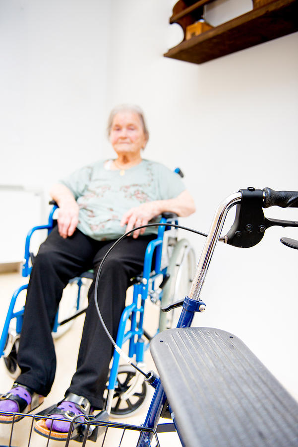Senior Woman In The Nursing Home Waiting On  Wheelchair Photograph by CasarsaGuru