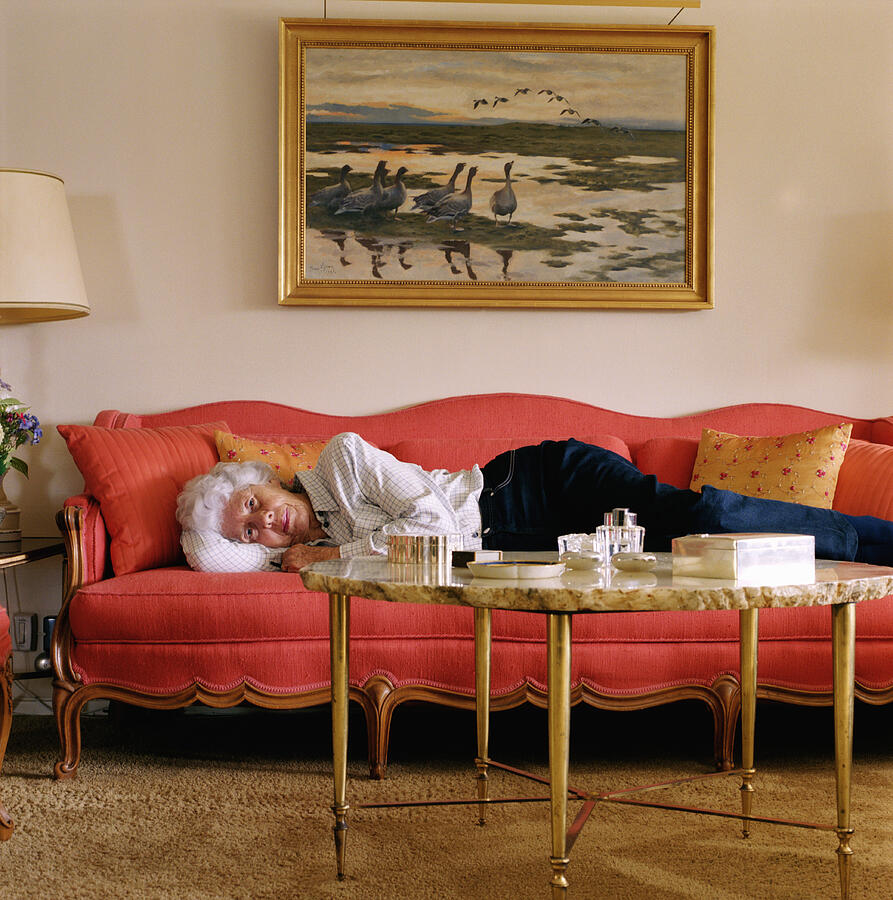 Senior woman lying on sofa, portrait Photograph by Anna Moller