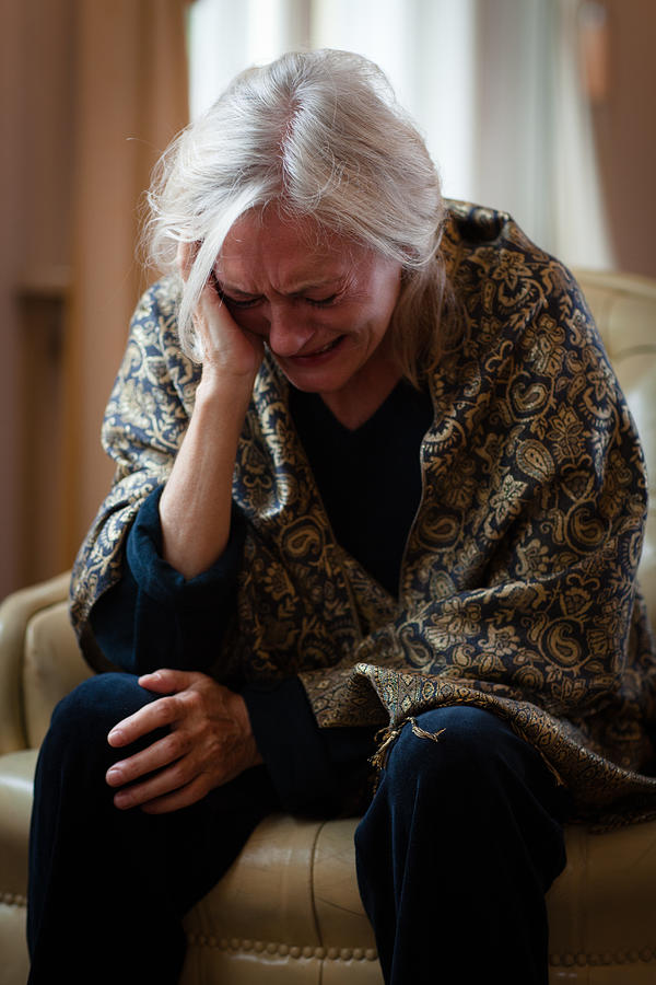 Senior Woman Sits Alone In Living Room And Cry Photograph by Fotografixx