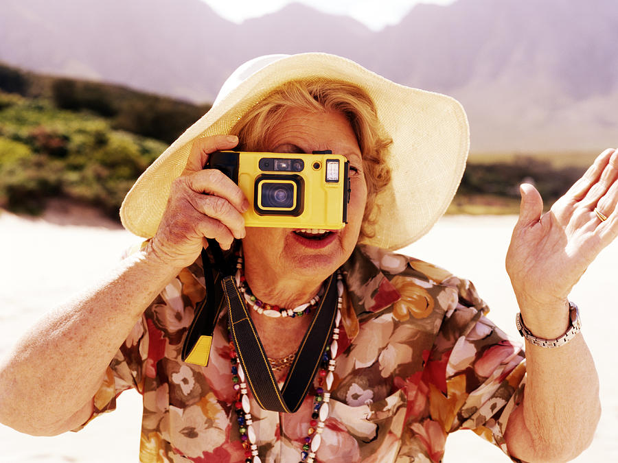 Senior woman taking photograph outdoors Photograph by Digital Vision