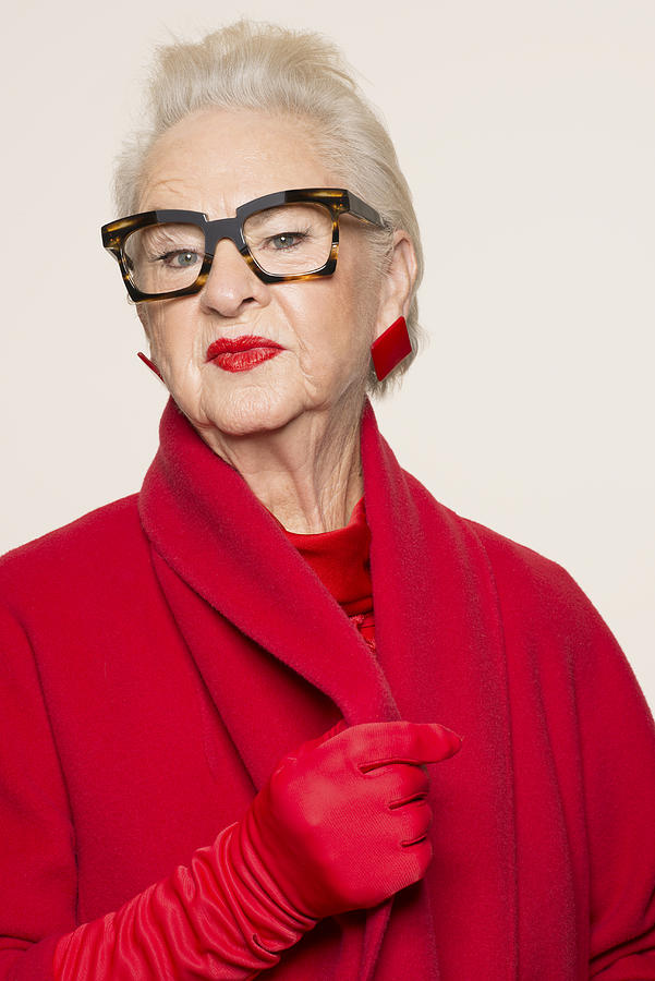Senior woman wearing glasses and red coat Photograph by Compassionate Eye Foundation