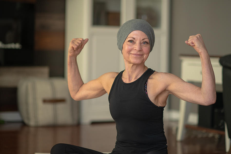 Senior woman with cancer flexing Photograph by FatCamera