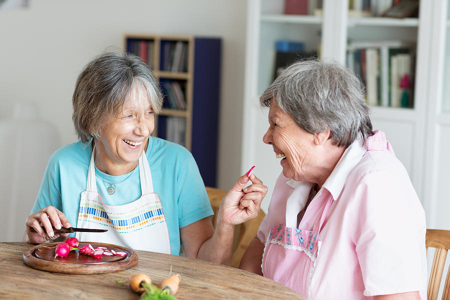 Senior Women Having Fun Cooking Together Photograph by SilviaJansen