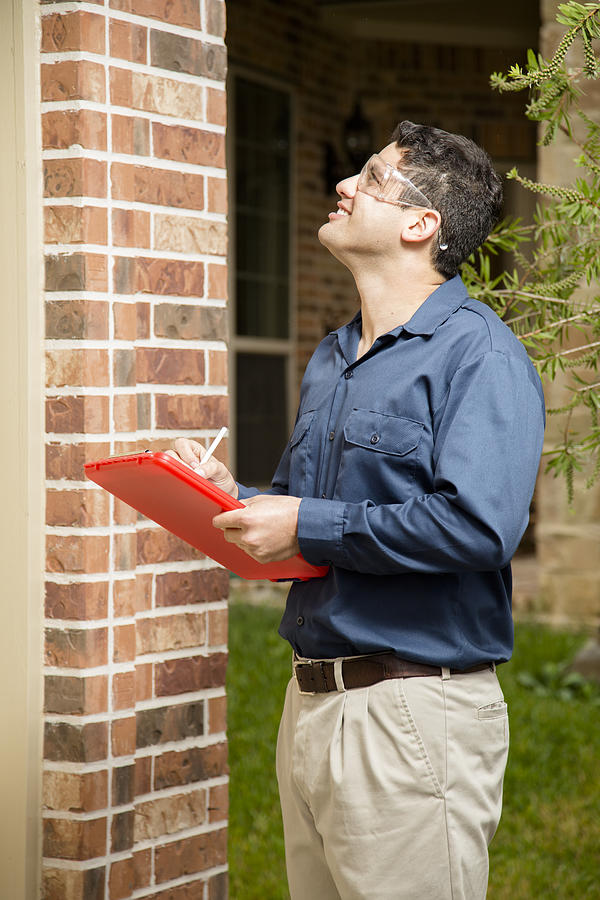 Service Industry: Repairman or inspector outside a residential home. Clipboard. Photograph by Fstop123