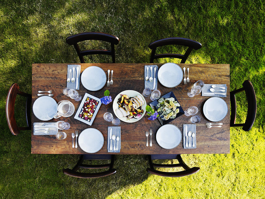 Set dinner table outside on grass lawn Photograph by Thomas Barwick