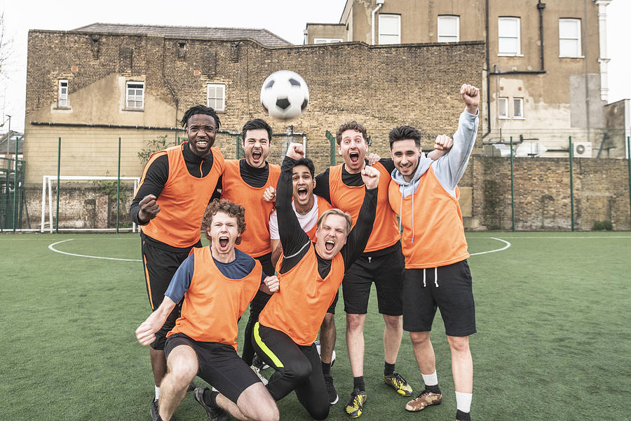 Seven a side football team cheering with ball in the air Photograph by JohnnyGreig