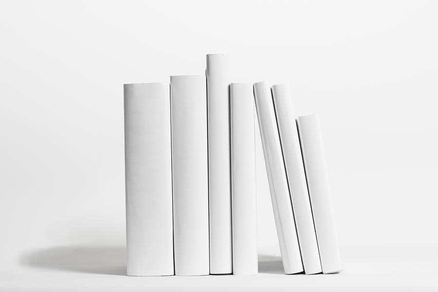 Seven white books in front of white background Photograph by Westend61