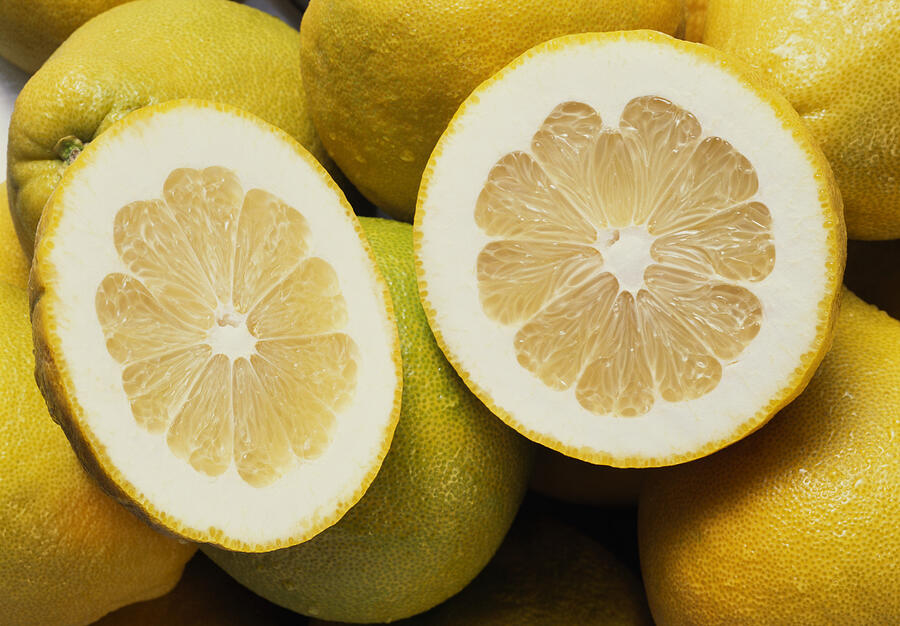 Several whole pomelos and two pomelo halves (close-up) Photograph by Image Professionals GmbH