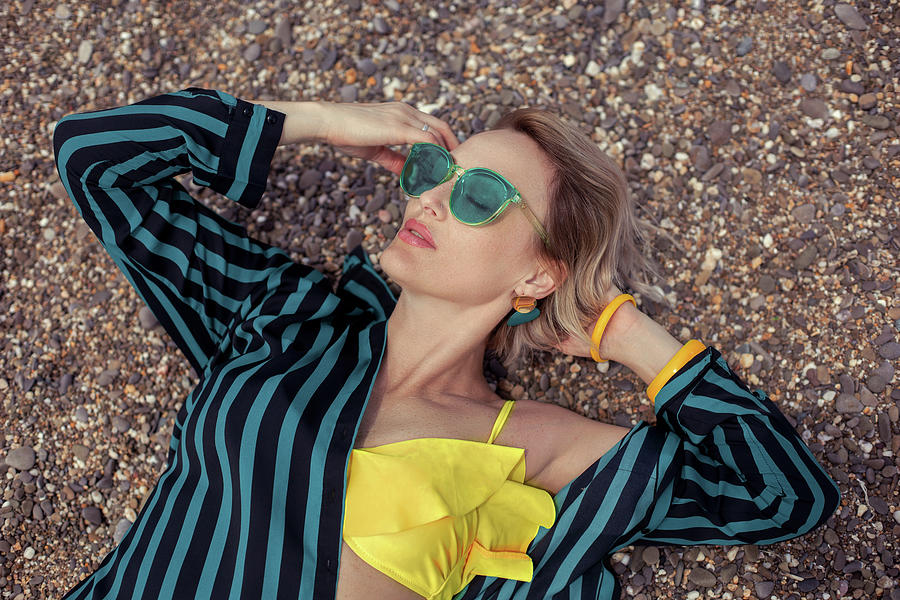Sexy Woman In A Yellow Swimsuit, A Striped Green Shirt And Sunglasses Lies On The Beach Photograph