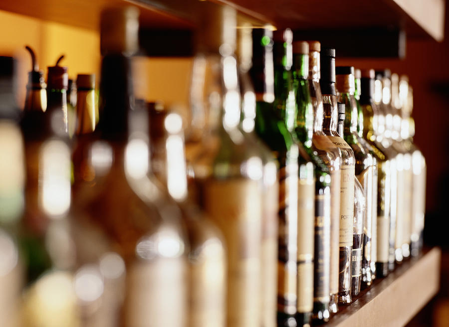 Shelf of liquor bottles (differential focus Photograph by Ryan McVay
