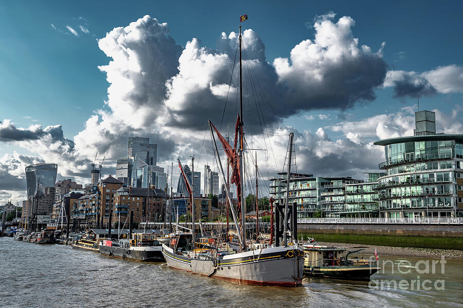 Ships And Boats Anchored On The River Thames In Front Of Modern Office Buildings In The City Of Lond Photograph by Andreas Berthold