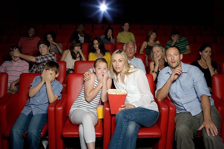 Shocked family in movie theater Photograph by Image Source