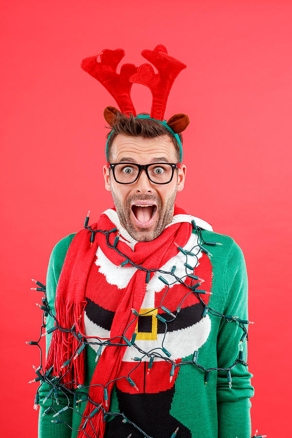 Shocked man in funny winter outfit against red background Photograph by Izusek