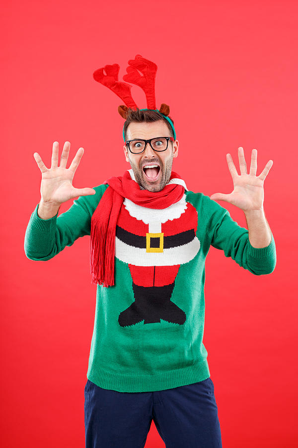 Shocked nerd man in funny winter outfit against red background Photograph by Izusek