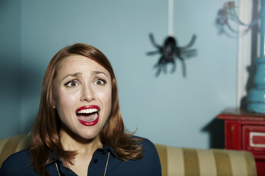 Shocked woman looking at spider. Photograph by Ezra Bailey