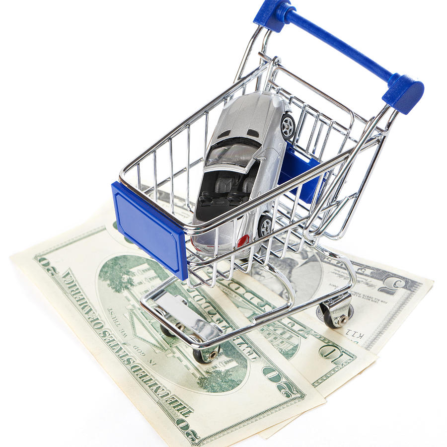 Shopping trolley with money and toy car Photograph by Sergeyryzhov