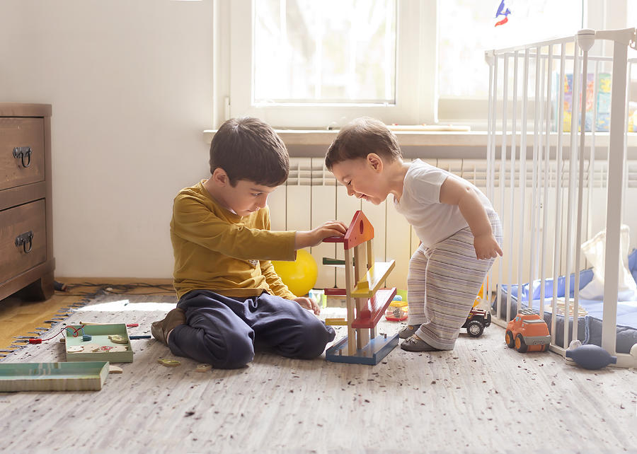 Sibling playing together with wooden toy Photograph by Anna Pekunova