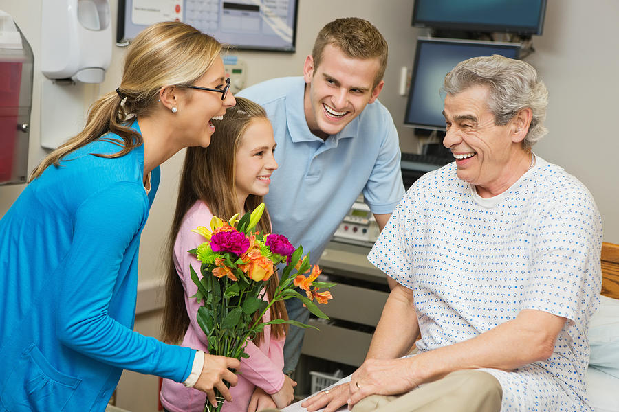 Sick grandfather visiting with family in hospital room Photograph by SDI Productions
