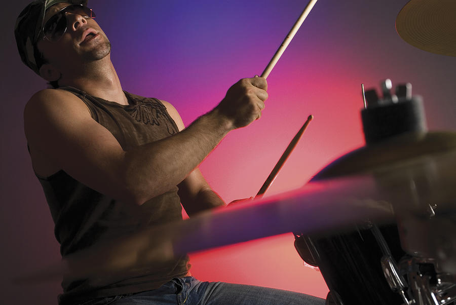 Side profile of a male drummer playing drums Photograph by Glowimages