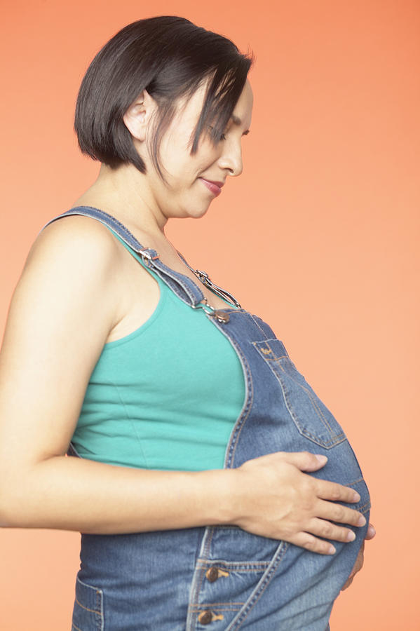 Side profile of a pregnant young woman holding her belly Photograph by Jack Hollingsworth