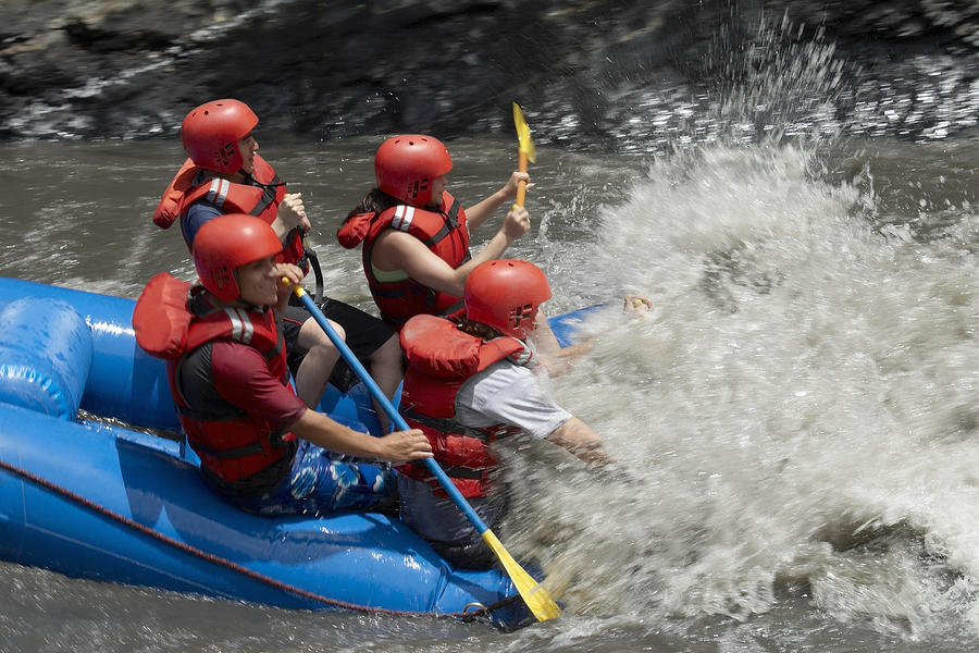 Side profile of four people rafting in a river Photograph by Glowimages